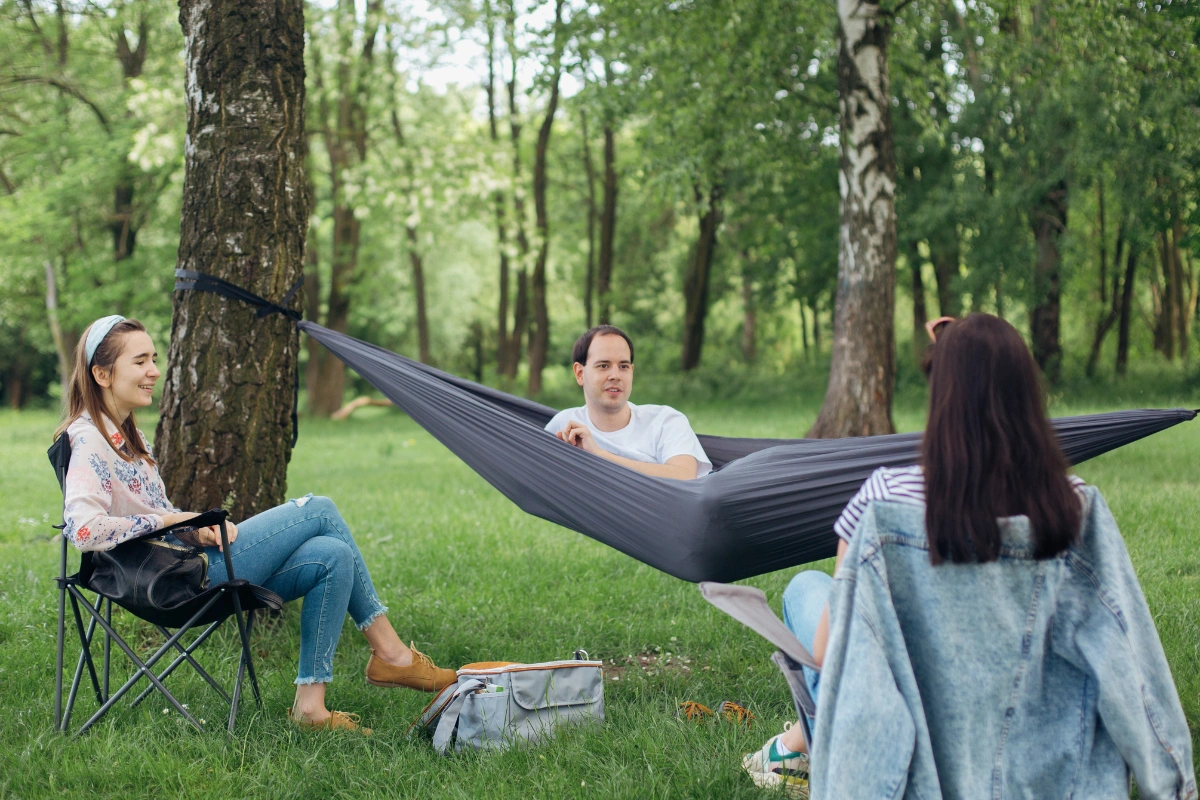 Friends relaxing with a hammock in a forest, enjoying time in nature