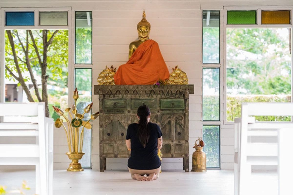 Woman practicing meditation and finding inner calm at a depression retreat in Thailand.