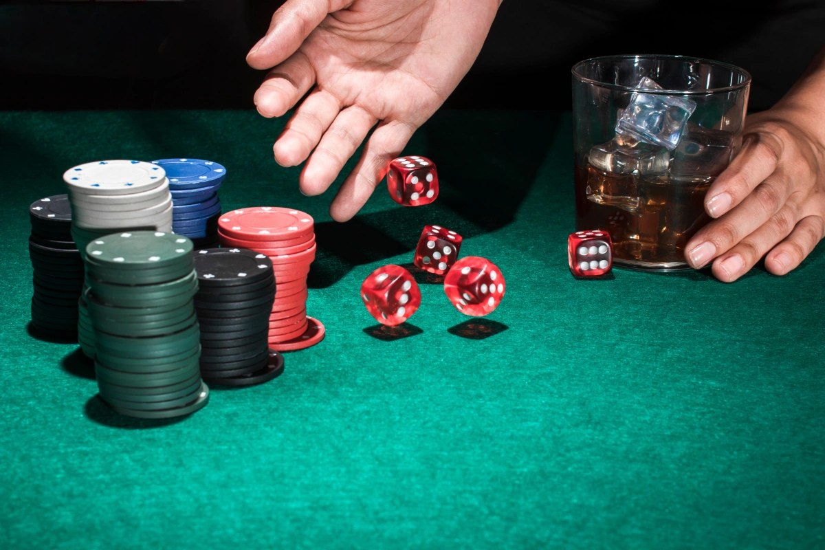 Casino chips, dice, and alcohol representing behavioral addiction and the need for gambling addiction treatment in Thailand.