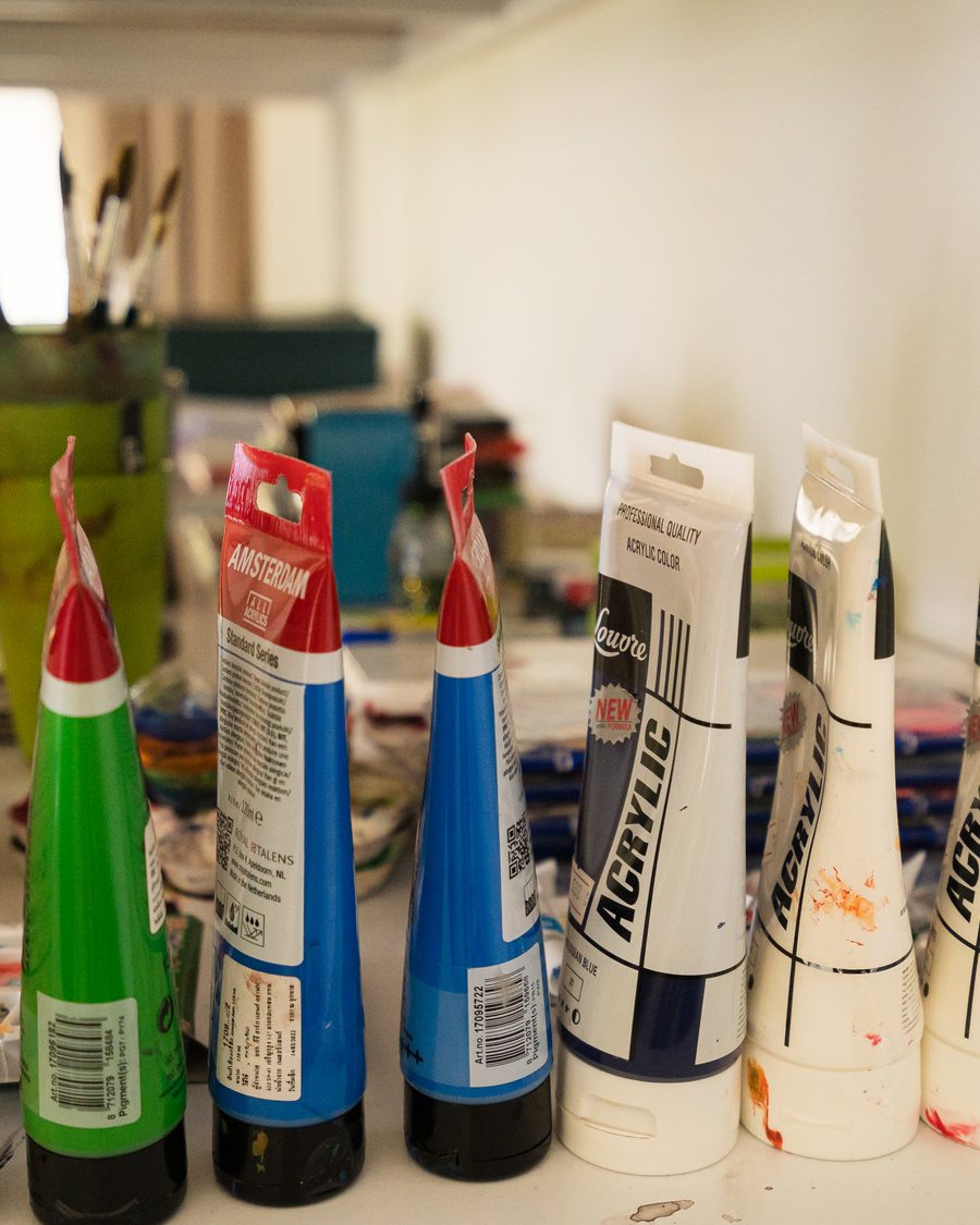 Acrylic paints lined up on the bench in the art therapy studio
