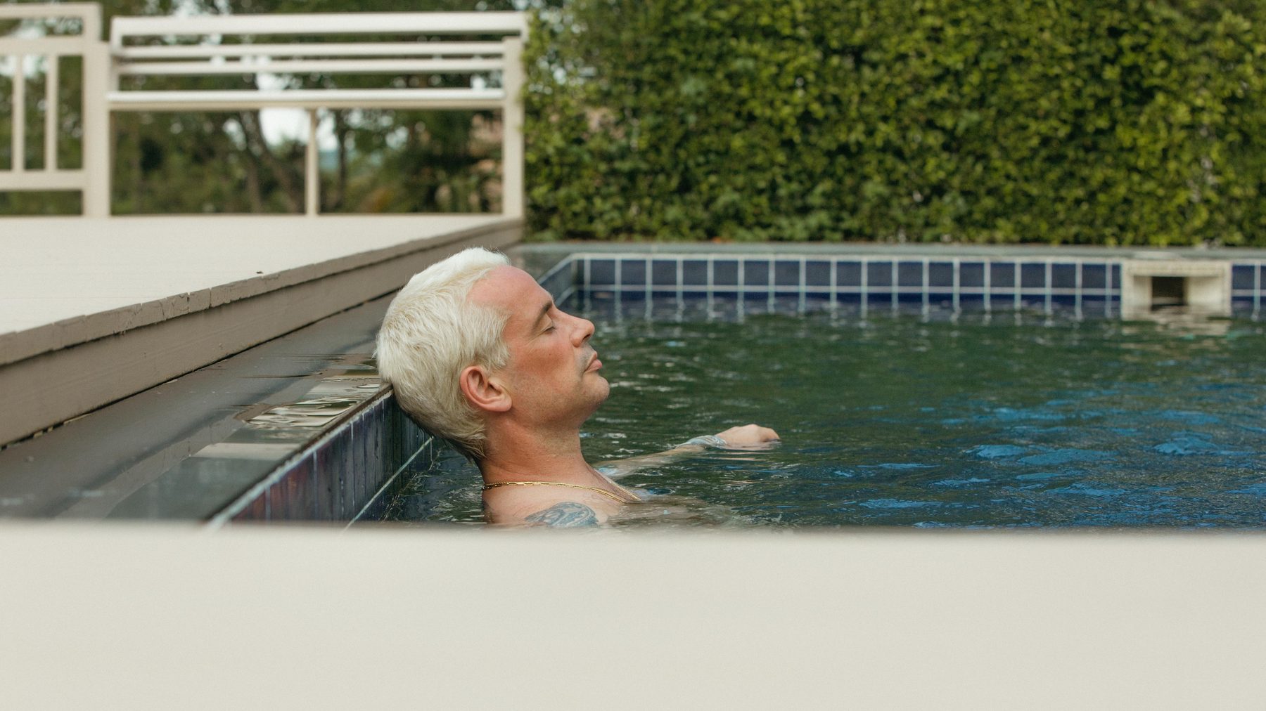 A client resting at the edge of the pool at the end of the day