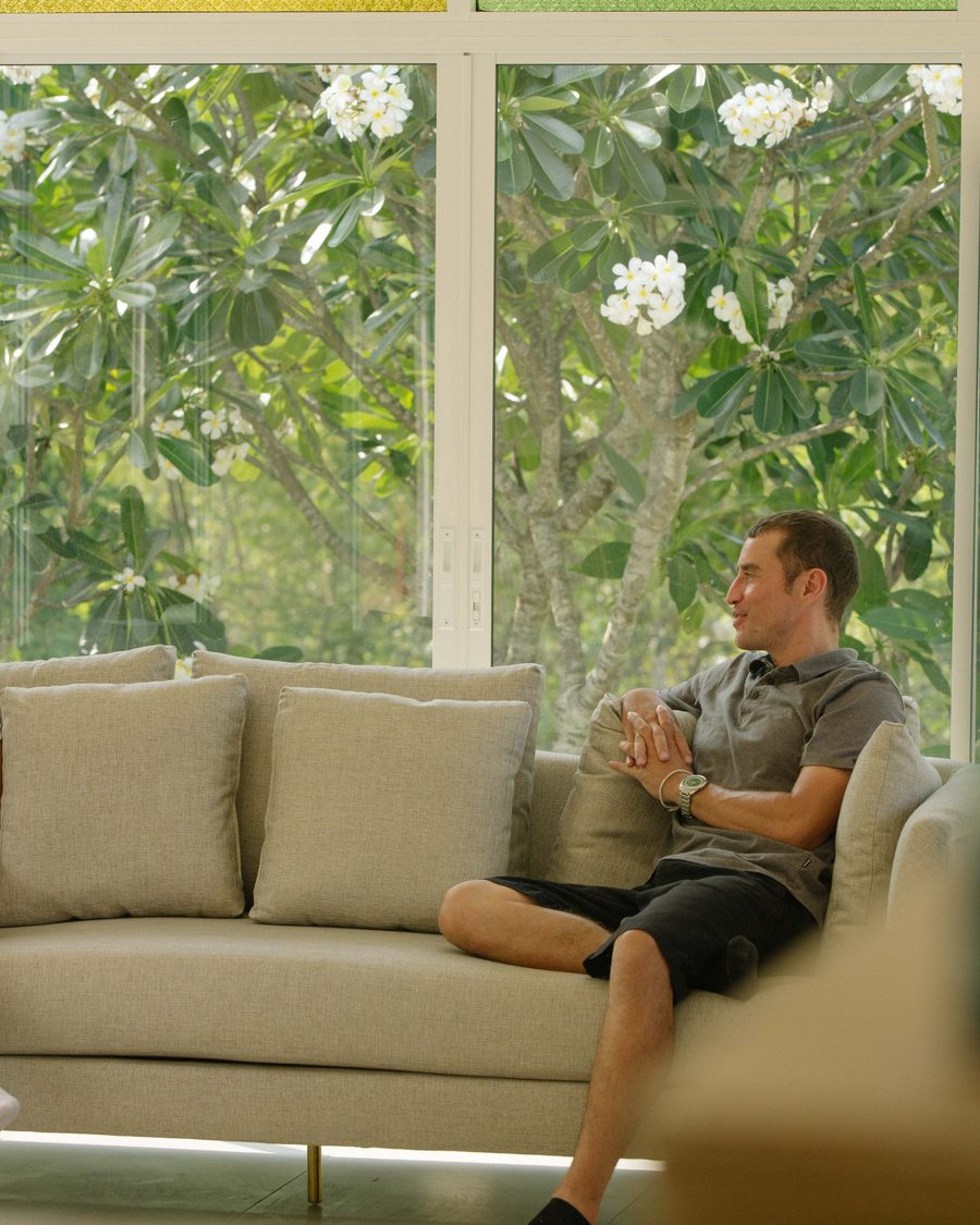A client seated in the sunroom, looking out to the frangipani