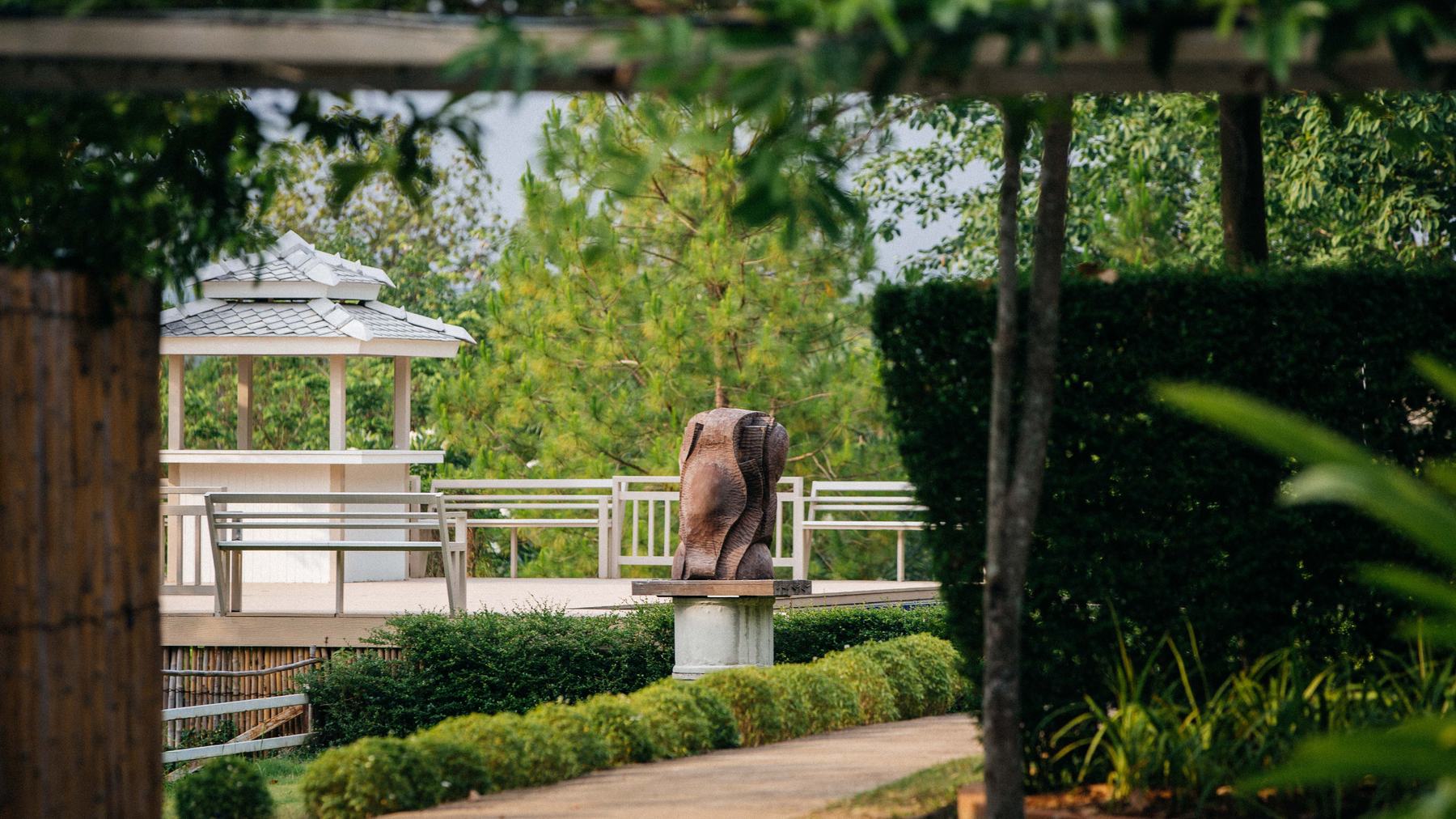 A garden pavilion standing beyond clipped hedges in the grounds