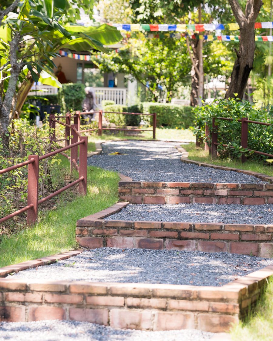 Brick steps rising along a gravel path between clipped beds in the gardens