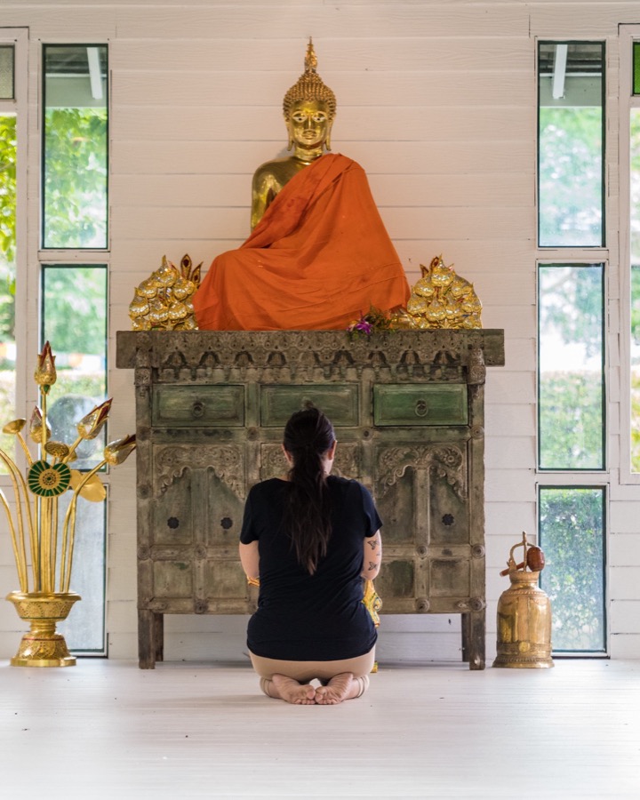 A client sitting in meditation before the shrine in the sala